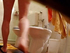 Totally naked  on toilet, pissing