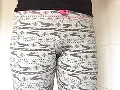 Precise babe in arms in black top standing peeing in pajama pants