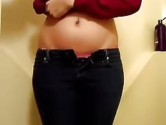 Ill-lighted cosset with glasses pees her jeans in batht
